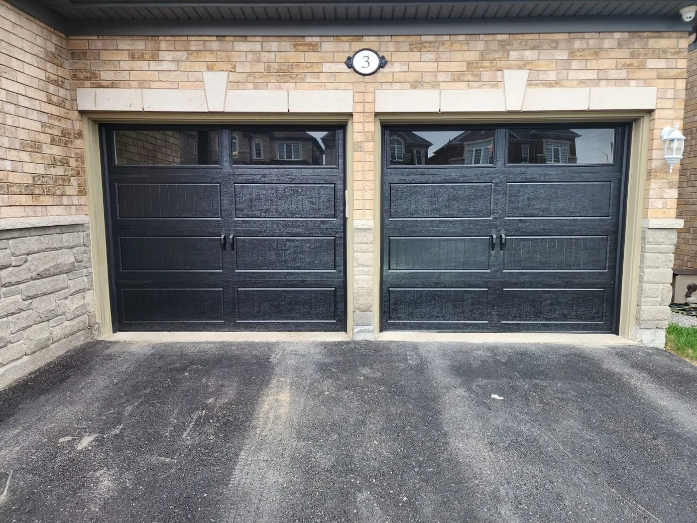 Black carriage-style double garage door with diamond windows — GTA