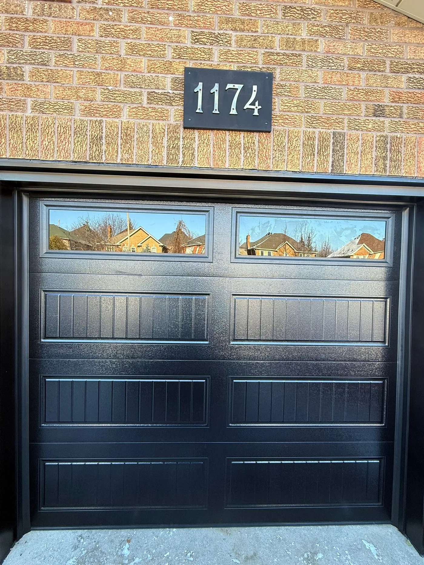 Black carriage-style single garage door with grid windows — GTA
