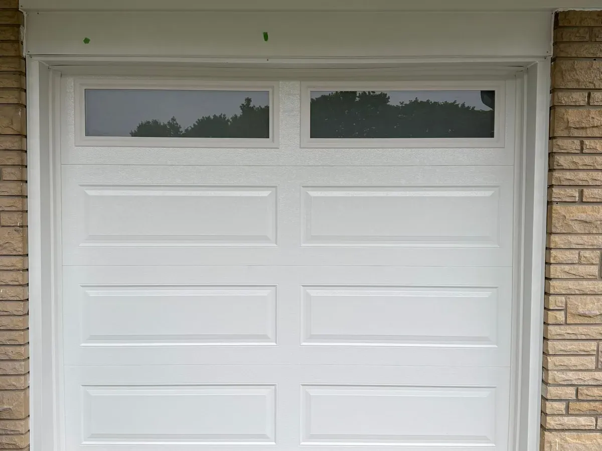 Black flush-panel garage door installation — Oakville