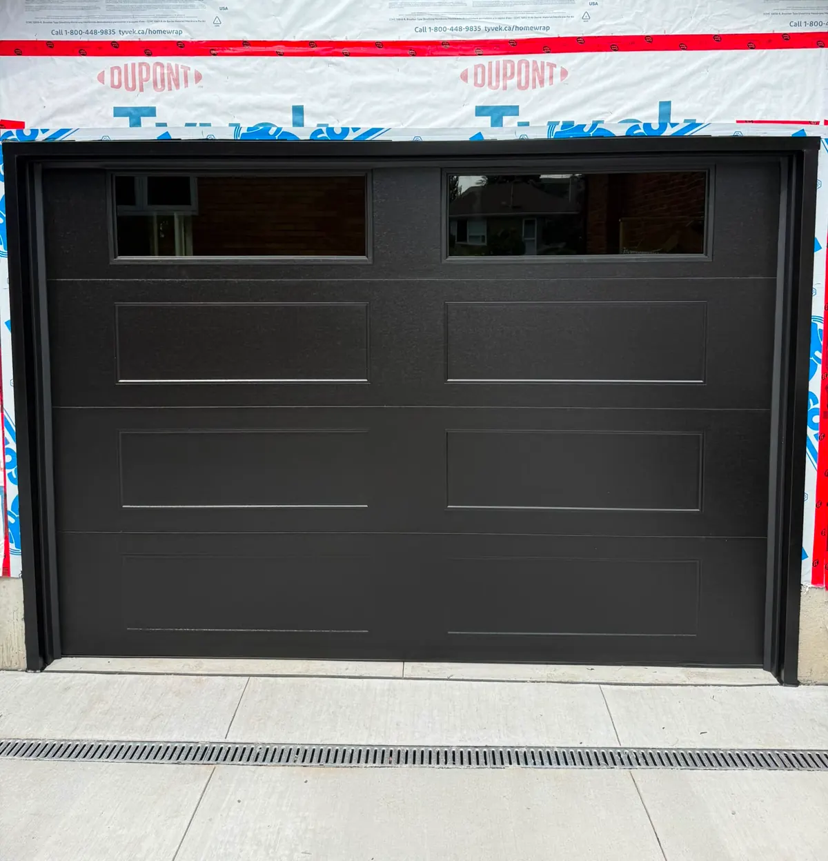 Black long-panel single garage door on a new-build home — GTA