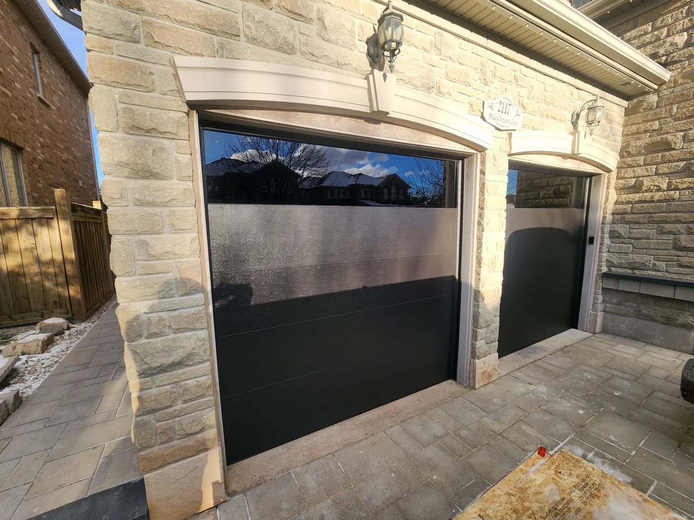 Black modern flush-panel garage door with a glass band — GTA
