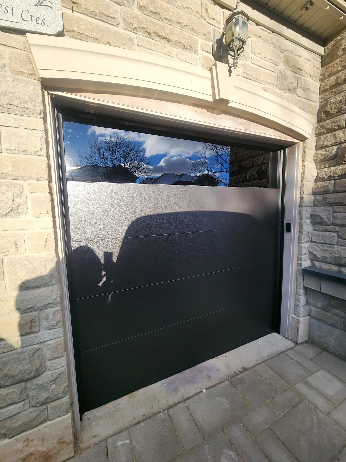 Black modern flush-panel garage door, installation in progress — GTA