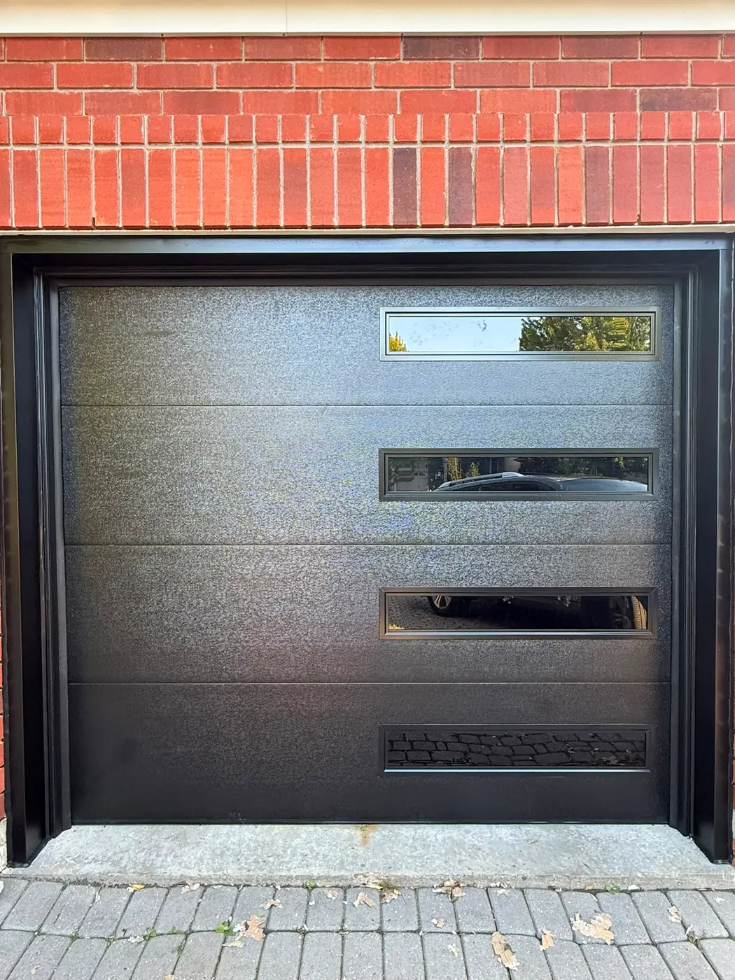 Black modern flush-panel single garage door with side windows — GTA