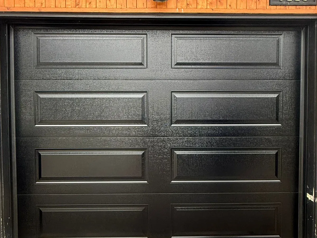Black raised-panel single garage door installation — Toronto