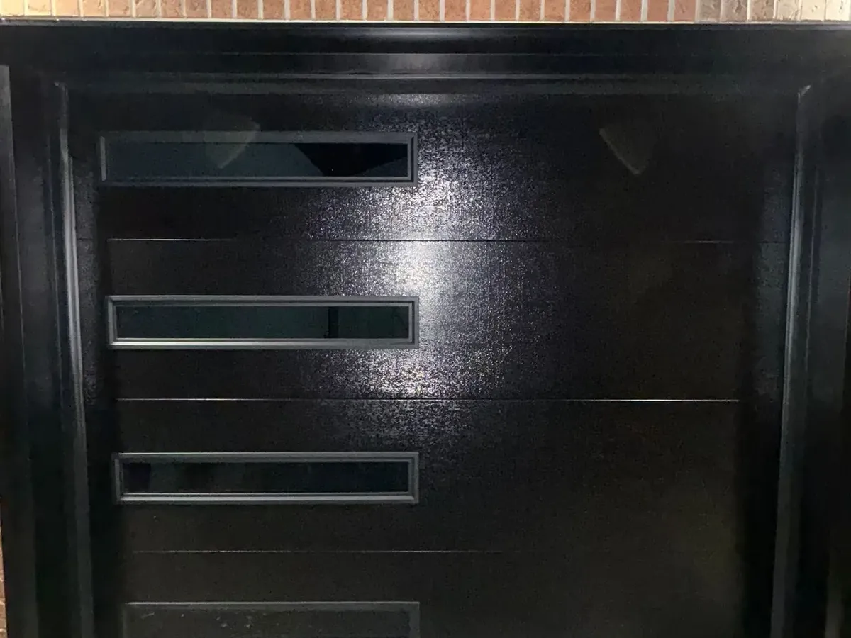 Black single modern garage door with side glass — Toronto
