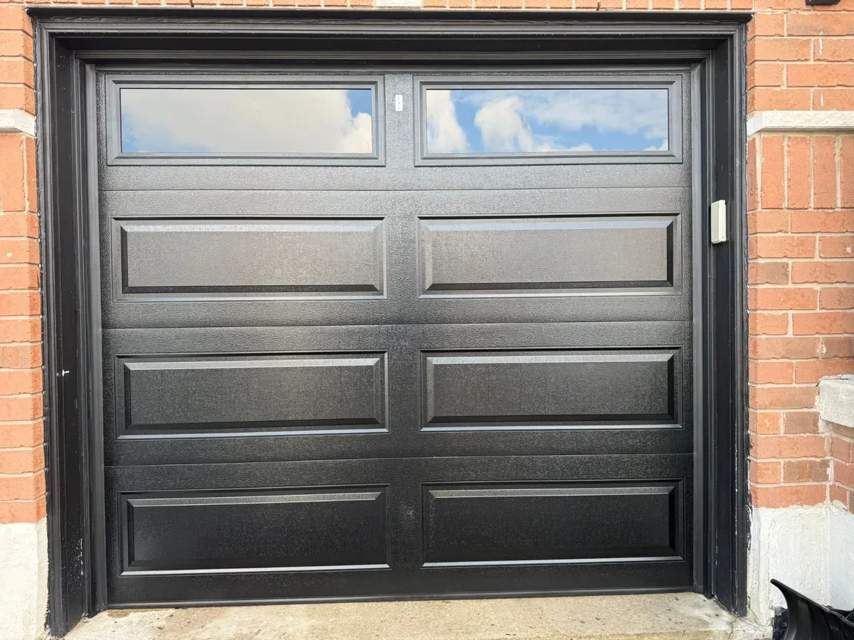 Black single raised-panel garage door with windows — Toronto