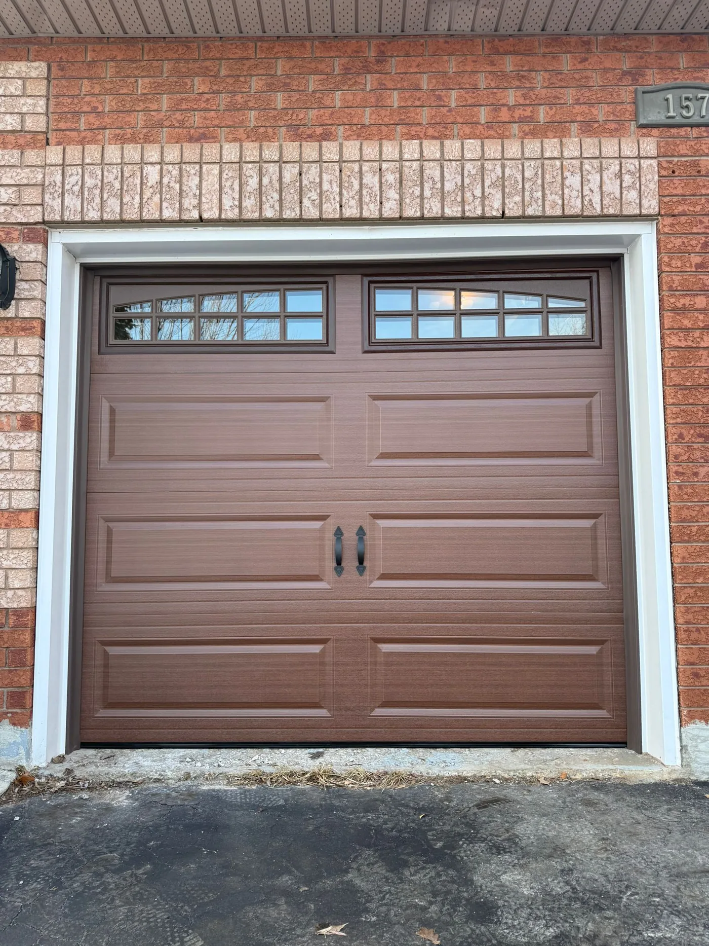 Brown carriage-style single garage door with arch windows — GTA