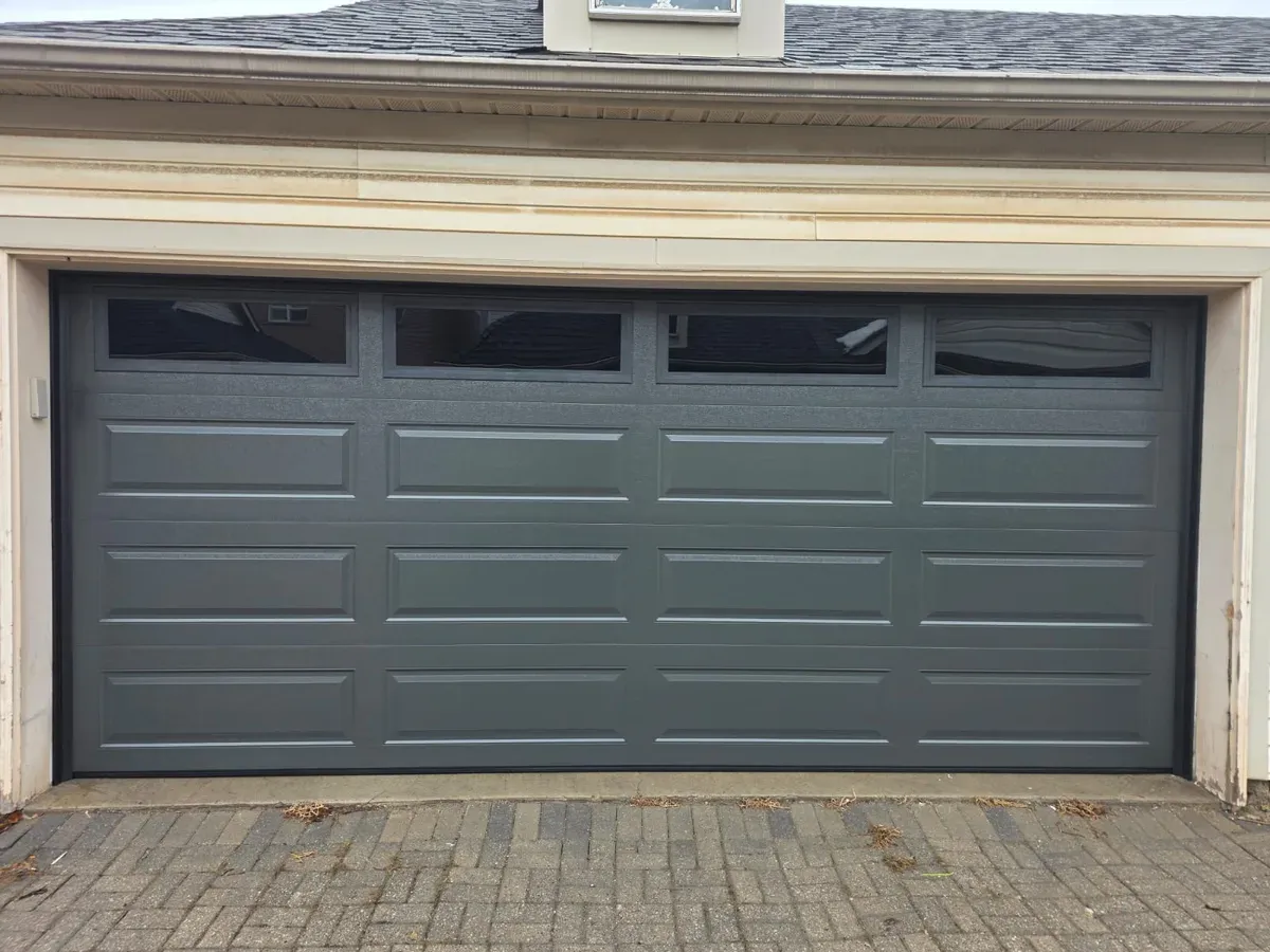 Dark grey double sectional garage door with top windows — Oakville