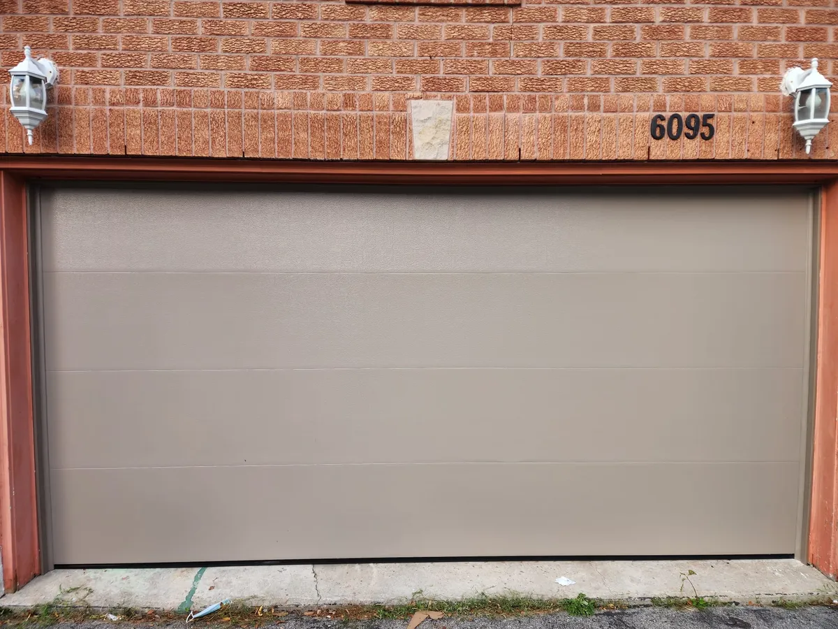 Beige flush-panel double garage door installation — GTA