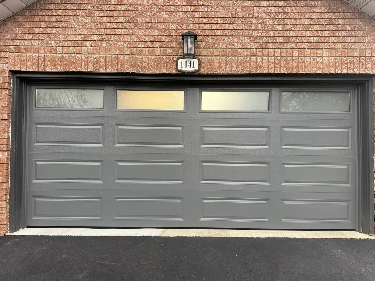 Grey double sectional garage door with top windows — Brampton