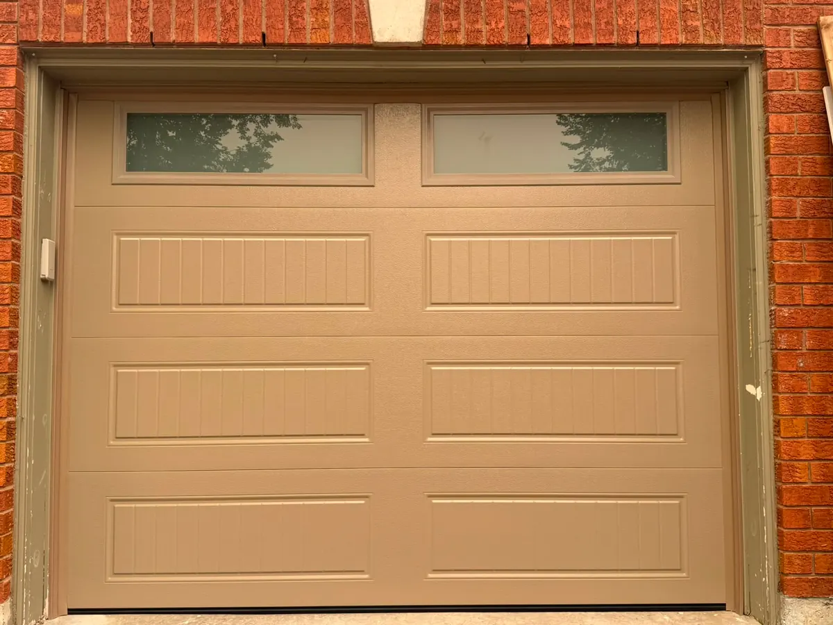 Tan carriage-panel single garage door with top windows — GTA